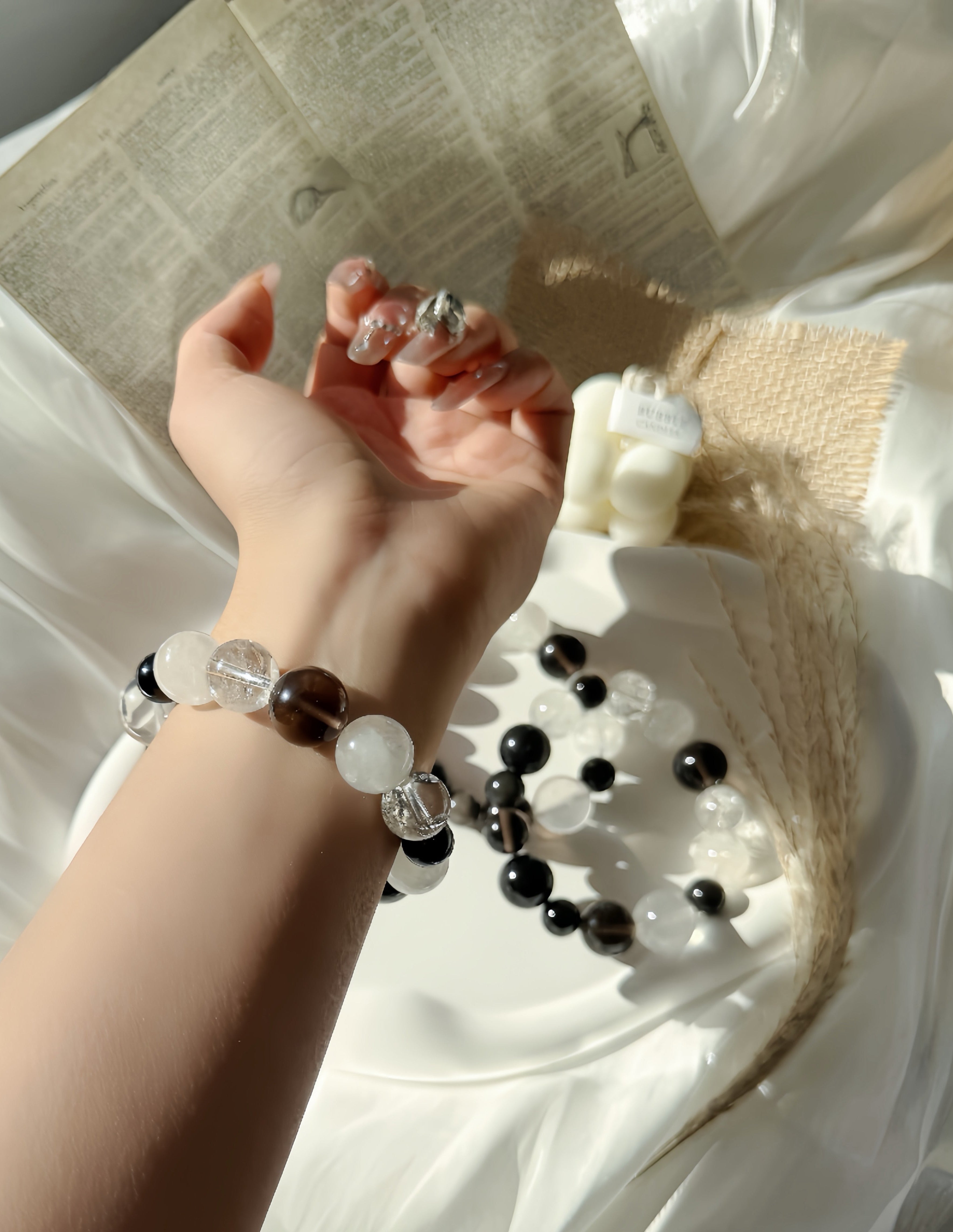 Hand wearing a beaded bracelet with a blurred background